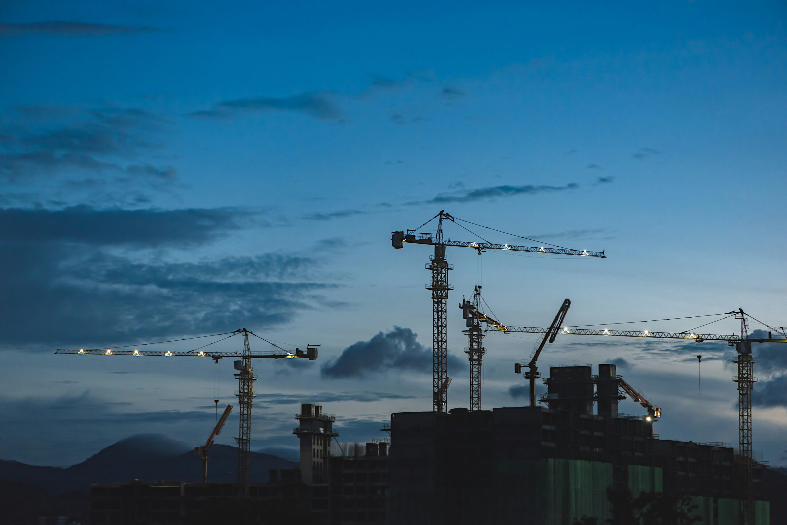 Construction site with multiple tower cranes operating at dusk, representing Chema Foam’s construction services 